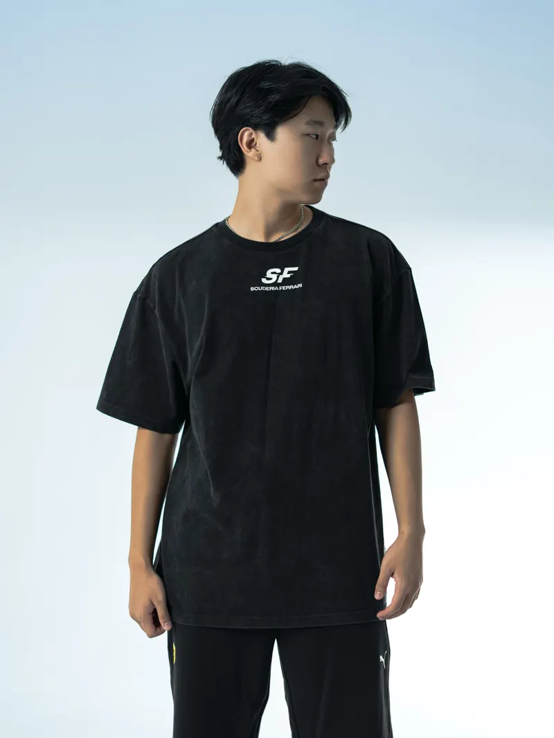 A model in a black t-shirt against a pale gradient backdrop