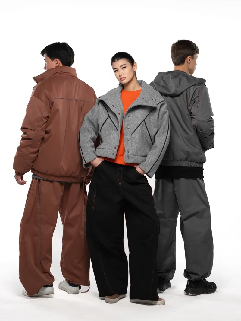 Three models in outerwear against a white backdrop
